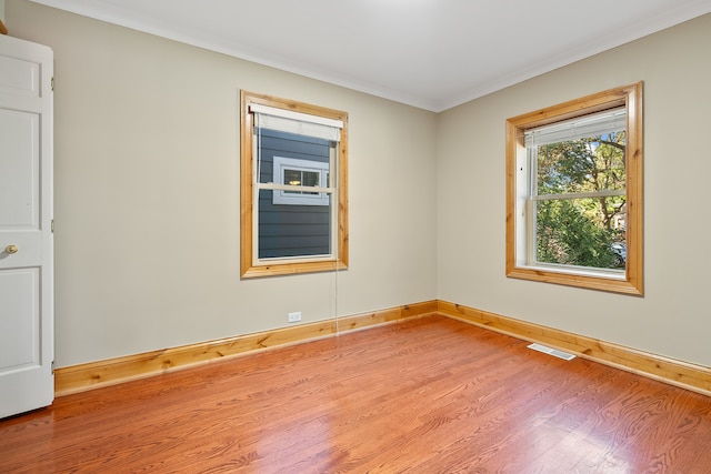 empty room featuring hardwood / wood-style flooring and crown molding