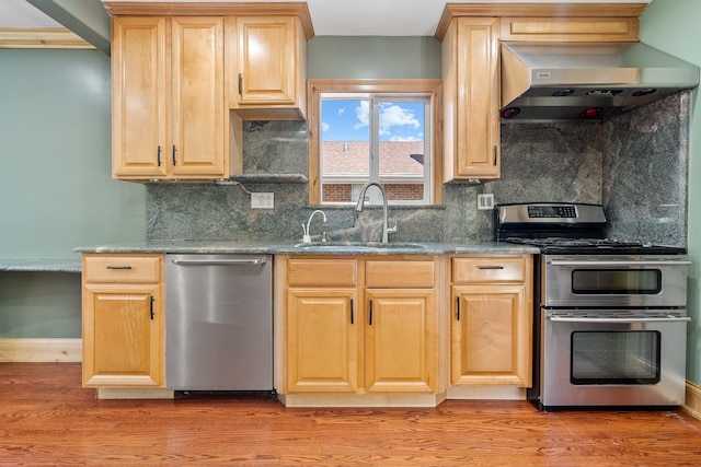 kitchen featuring decorative backsplash, stainless steel appliances, light wood-type flooring, sink, and extractor fan