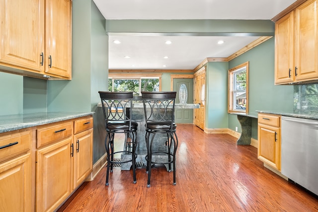 kitchen featuring wood-type flooring, plenty of natural light, crown molding, and stainless steel dishwasher