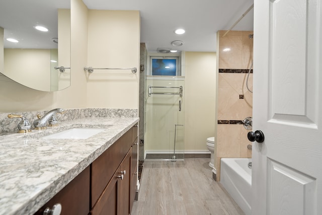 full bathroom featuring shower with separate bathtub, vanity, toilet, and hardwood / wood-style floors