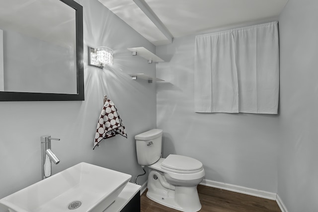 bathroom featuring wood-type flooring, toilet, and sink