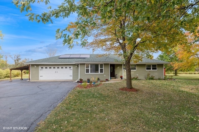 single story home featuring a front yard, a garage, and a carport