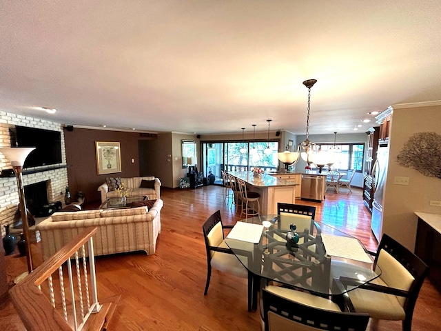 dining room with ornamental molding, a fireplace, and hardwood / wood-style floors