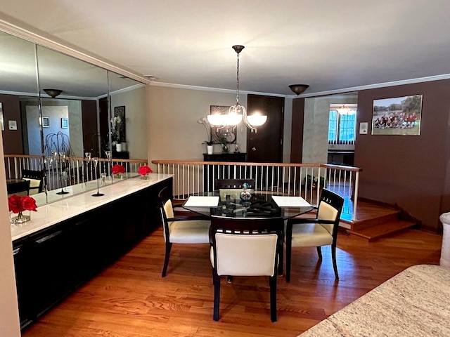 dining area with a notable chandelier, crown molding, and wood-type flooring