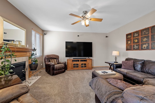 living room featuring carpet flooring, a tiled fireplace, and ceiling fan