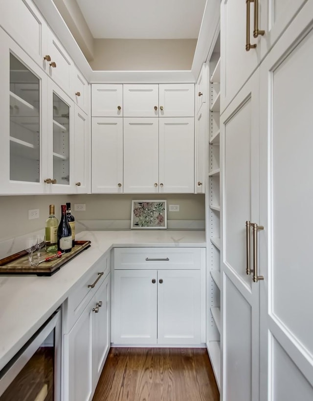 kitchen featuring hardwood / wood-style flooring, white cabinets, and beverage cooler