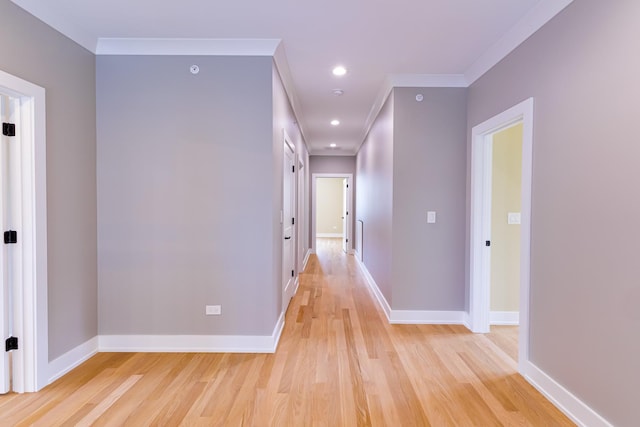 hall with ornamental molding and light hardwood / wood-style flooring