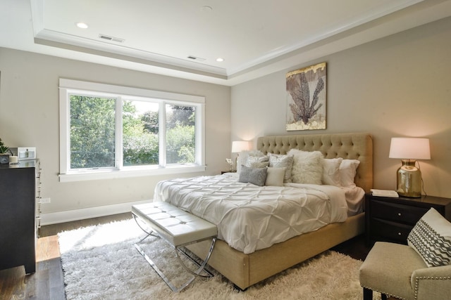 bedroom featuring hardwood / wood-style flooring and a tray ceiling