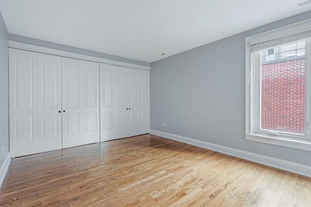 unfurnished bedroom with light hardwood / wood-style flooring and a closet