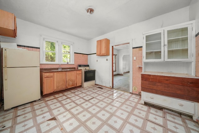 kitchen featuring white appliances, sink, and light tile patterned floors