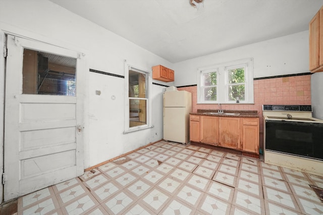 kitchen with tile walls, white appliances, and sink