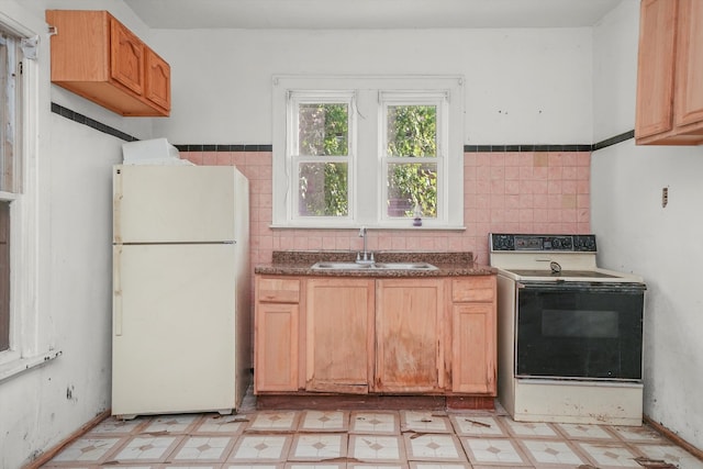 kitchen with tile walls, white appliances, and sink