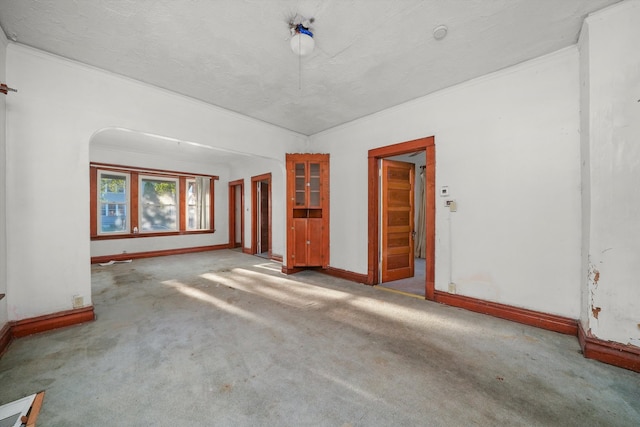 carpeted empty room with a textured ceiling and ornamental molding