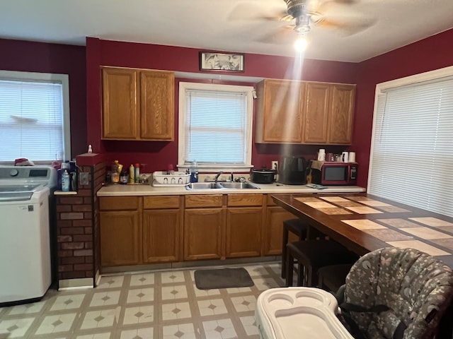 kitchen with washer / clothes dryer, ceiling fan, and sink