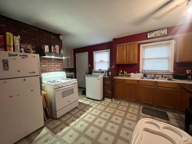 kitchen with washer / dryer, ventilation hood, sink, white appliances, and brick wall