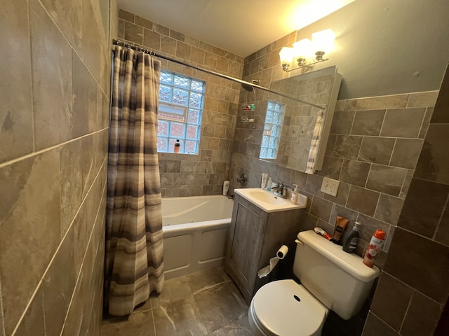 full bathroom with tile walls, vanity, toilet, and shower / bath combo