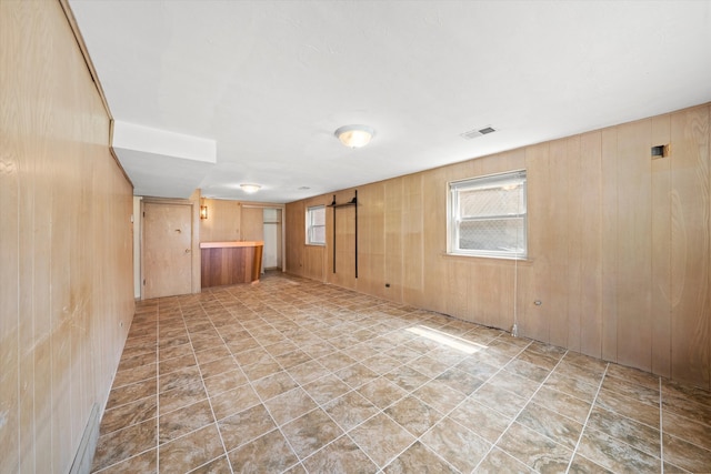 basement with a barn door and wooden walls