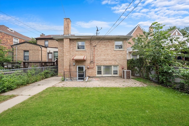 rear view of property featuring a lawn, cooling unit, and a patio