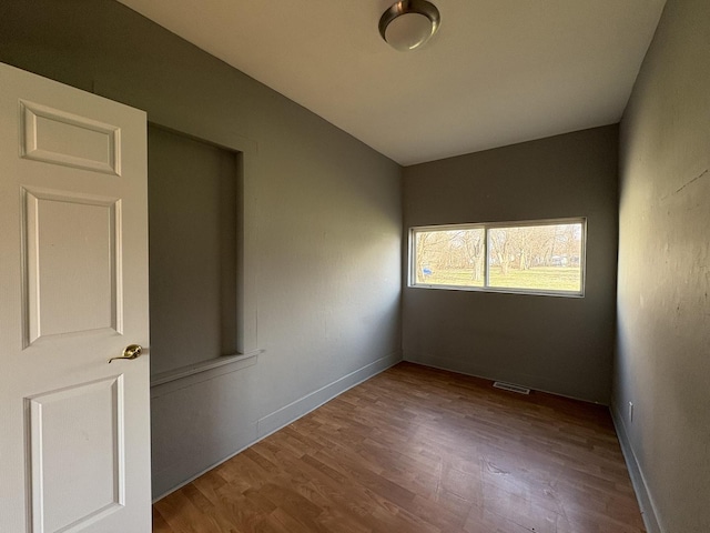 unfurnished room featuring visible vents and wood finished floors