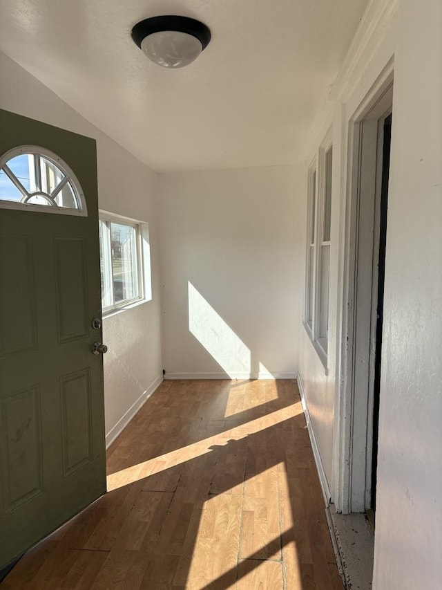 foyer entrance with dark wood-type flooring and baseboards
