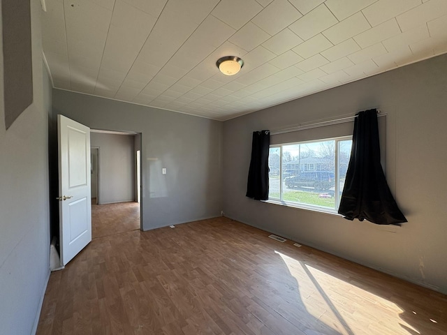 spare room featuring visible vents and wood finished floors