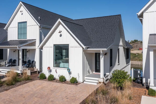 modern inspired farmhouse featuring central AC unit and a porch