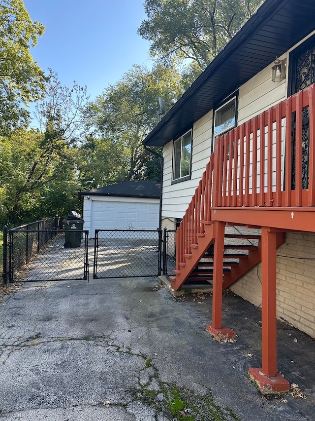 view of home's exterior featuring a wooden deck, an outdoor structure, and a garage