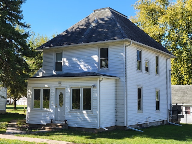 rear view of house featuring a lawn