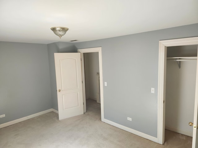 unfurnished bedroom featuring a closet and light colored carpet