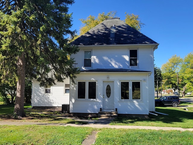 view of front of house with cooling unit and a front lawn