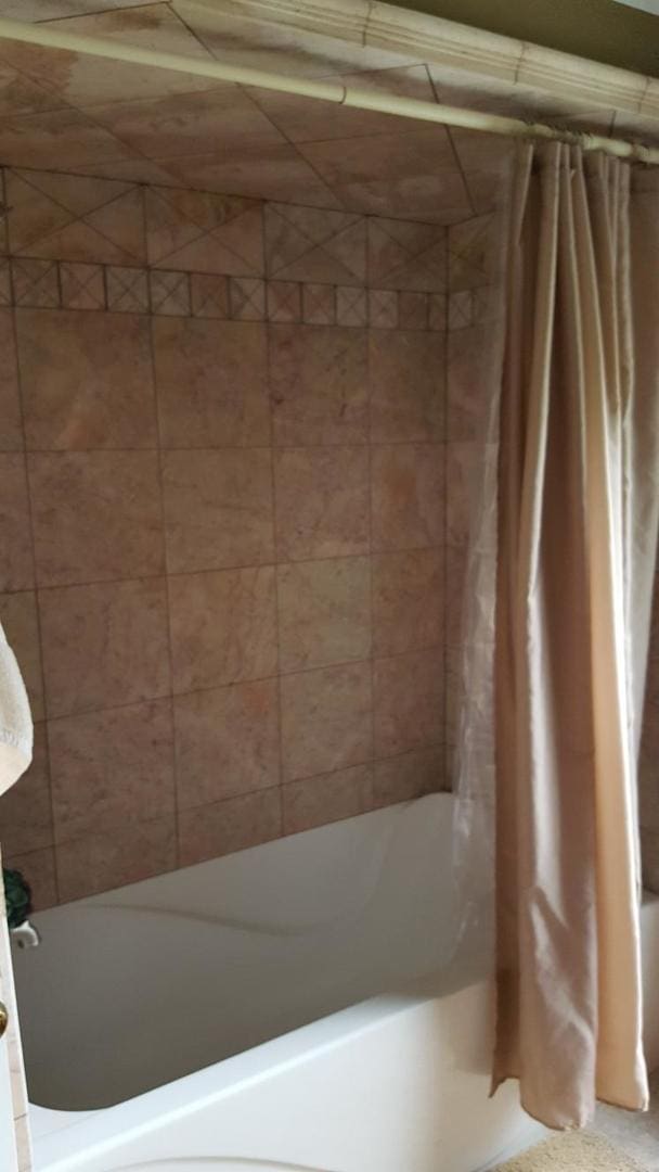 bathroom with shower / bath combination with curtain