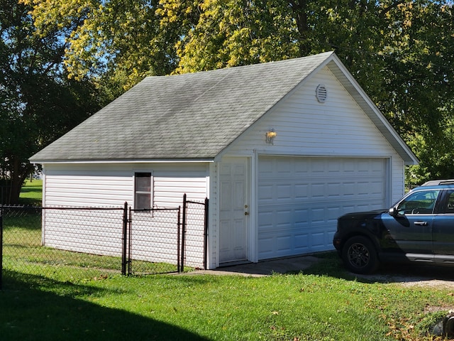 garage featuring wooden walls and a lawn