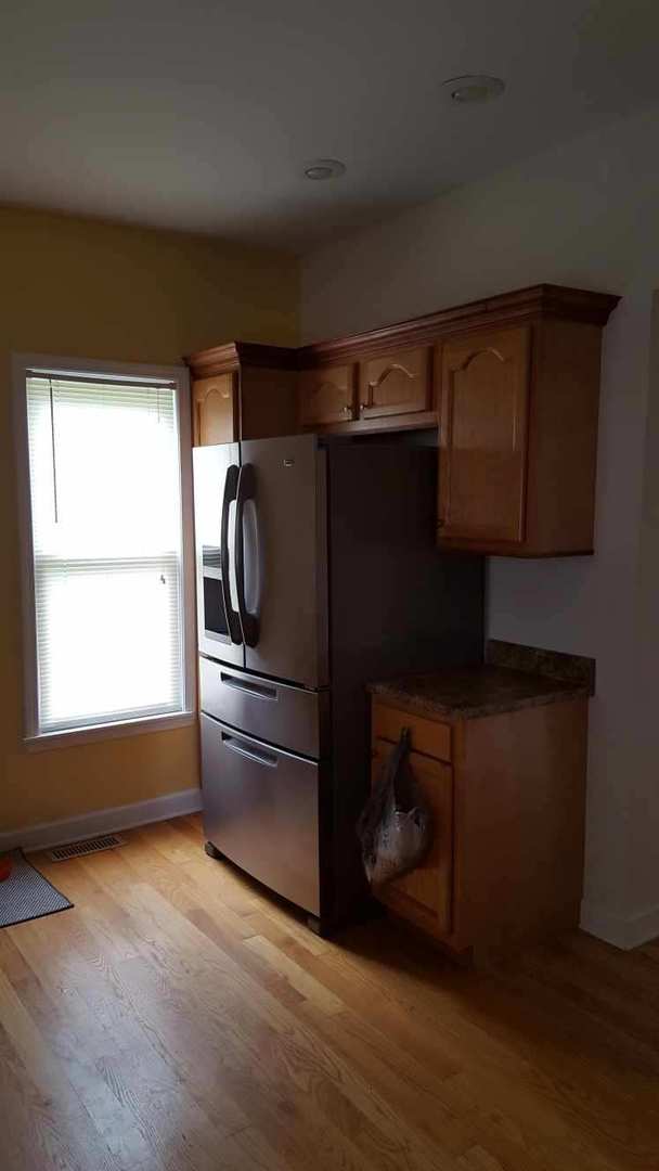 202 S Birch St, Wenona, IL 61377 - kitchen with light wood-type flooring, stainless steel fridge, dark countertops, and baseboards