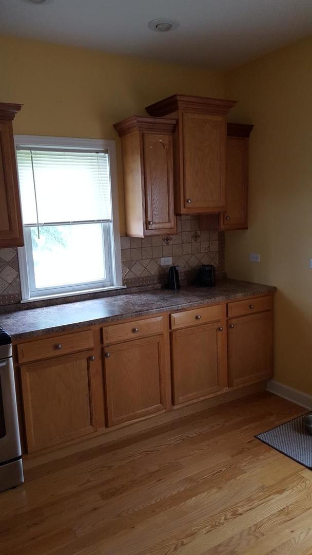 kitchen with stainless steel range with electric cooktop, light wood-type flooring, and decorative backsplash