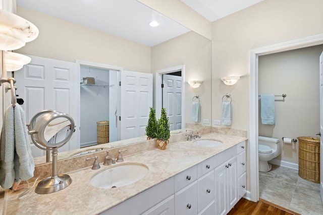 bathroom featuring vanity, toilet, and hardwood / wood-style flooring