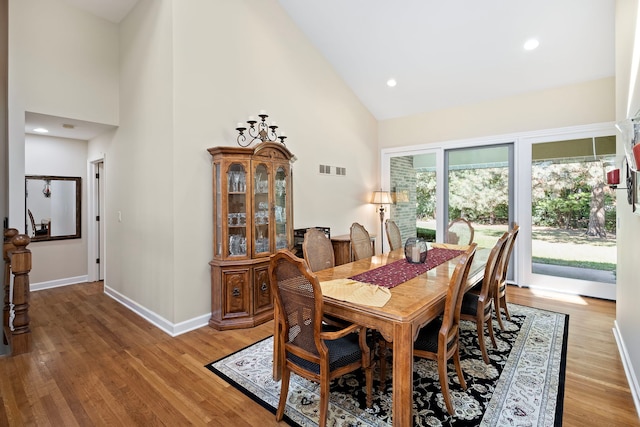 dining space featuring high vaulted ceiling and hardwood / wood-style floors