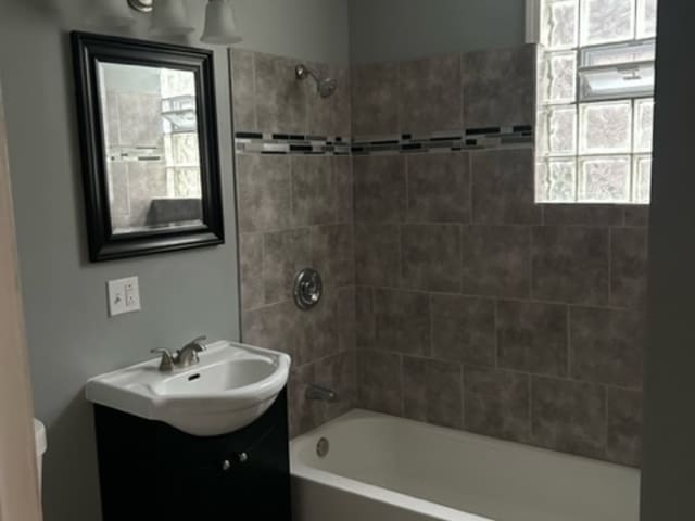 bathroom with vanity and tiled shower / bath