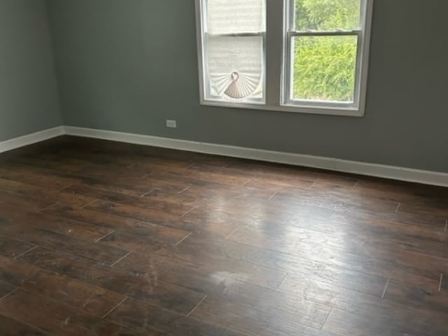 unfurnished room with dark wood-type flooring