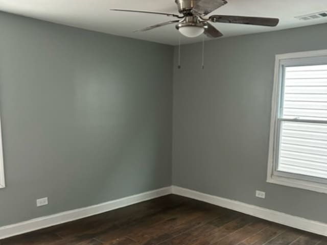 empty room featuring ceiling fan and dark wood-type flooring