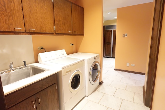 laundry room featuring light tile patterned floors, sink, independent washer and dryer, and cabinets