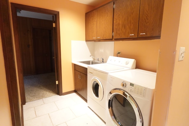 laundry room featuring cabinets, light tile patterned floors, washer and dryer, and sink