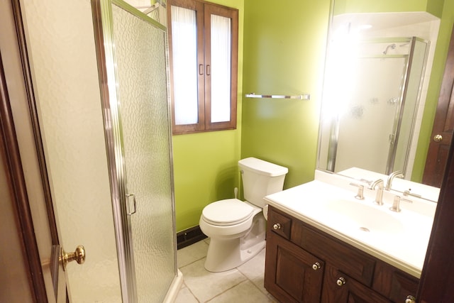 bathroom featuring tile patterned flooring, vanity, toilet, and an enclosed shower