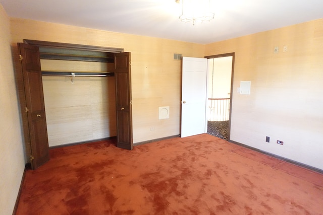 unfurnished bedroom featuring dark carpet and a closet