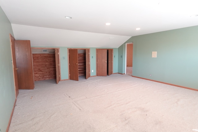 spare room with light colored carpet and lofted ceiling