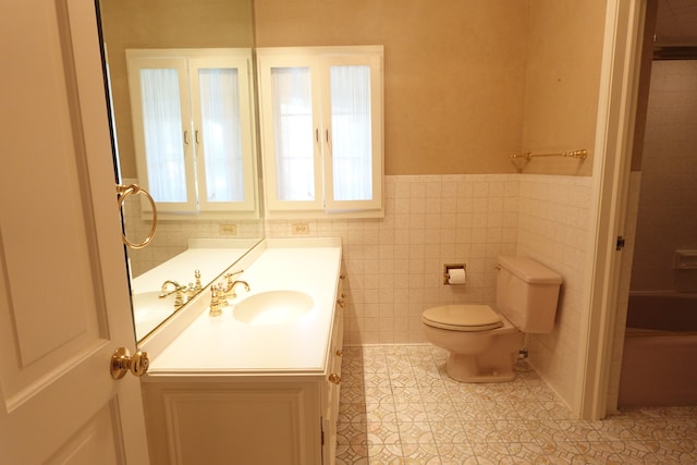 bathroom with tile walls, tile patterned flooring, vanity, and toilet