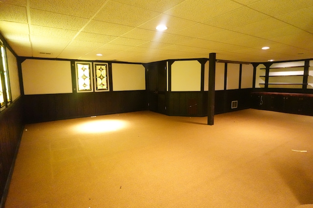 basement featuring a drop ceiling and carpet