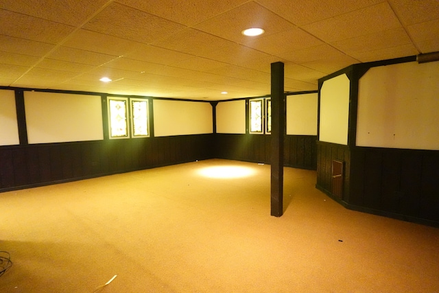 basement featuring a drop ceiling and carpet