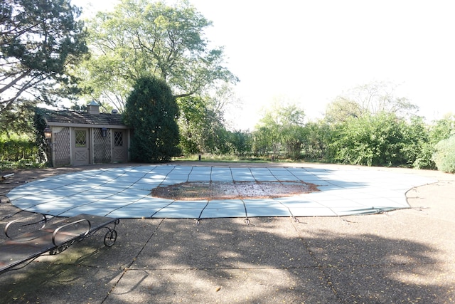 view of swimming pool featuring a patio and an outdoor structure