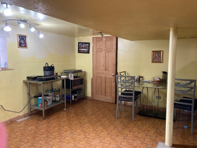 basement with a textured ceiling and parquet flooring