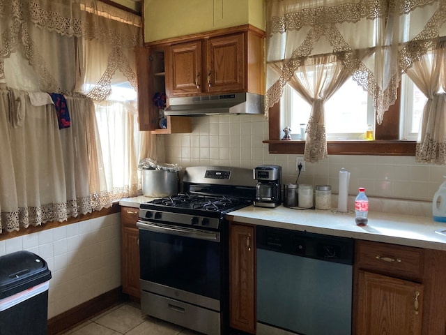 kitchen featuring light tile patterned flooring, appliances with stainless steel finishes, and decorative backsplash